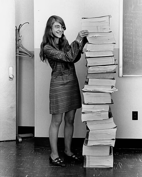 Margaret Hamilton with stacks of software code in print